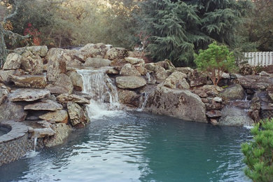 Pool fountain - huge rustic backyard stone and custom-shaped natural pool fountain idea in San Francisco