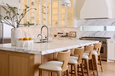 Inspiration for a large transitional l-shaped light wood floor and brown floor eat-in kitchen remodel in Dallas with an undermount sink, shaker cabinets, medium tone wood cabinets, marble countertops, white backsplash, marble backsplash, stainless steel appliances, an island and white countertops