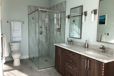 Inspiration for a mid-sized contemporary master bathroom in Denver with flat-panel cabinets, dark wood cabinets, a freestanding tub, a corner shower, a two-piece toilet, gray tile, porcelain tile, blue walls, porcelain floors, an undermount sink, engineered quartz benchtops, multi-coloured floor, a hinged shower door and grey benchtops.