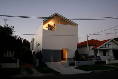 Photo of a mid-sized contemporary two-storey white exterior in Sydney with wood siding and a gable roof.