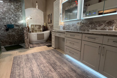Example of a mid-sized trendy master brown tile and marble tile porcelain tile, beige floor and double-sink bathroom design in Tampa with shaker cabinets, white cabinets, a bidet, beige walls, a drop-in sink, marble countertops, a hinged shower door, brown countertops and a built-in vanity