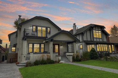 Imagen de fachada de casa blanca y gris clásica de tamaño medio de dos plantas con revestimiento de estuco, tejado a doble faldón, tejado de teja de madera y panel y listón