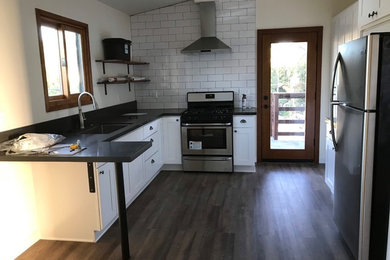 Inspiration for a small modern l-shaped vinyl floor and multicolored floor eat-in kitchen remodel in San Diego with an undermount sink, shaker cabinets, white cabinets, quartz countertops, white backsplash, subway tile backsplash, stainless steel appliances, a peninsula and gray countertops