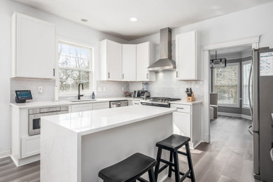 Eat-in kitchen - mid-sized transitional l-shaped eat-in kitchen idea in Philadelphia with shaker cabinets, white cabinets, quartz countertops, an island and white countertops