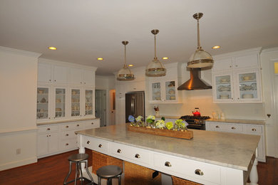 Elegant kitchen photo in Raleigh with white backsplash and an island