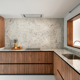 Ejemplo de cocina en L, contemporánea, sin isla, con fregadero bajoencimera, armarios con paneles lisos, puertas de armario de madera oscura, salpicadero verde, salpicadero de losas de piedra, suelo gris y encimeras grises