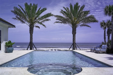 This is an example of a mid-sized traditional backyard rectangular pool in Jacksonville with natural stone pavers.