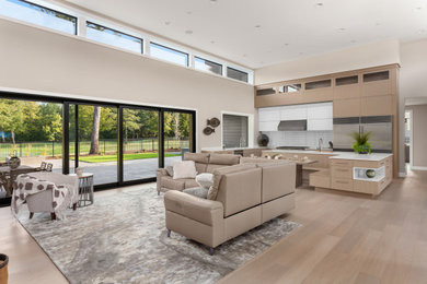Contemporary open concept living room in Portland with beige walls, light hardwood floors and beige floor.
