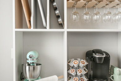 Mid-sized l-shaped home bar photo in Chicago with shaker cabinets and medium tone wood cabinets