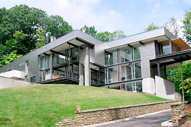 Example of a large three-story mixed siding flat roof design in Kansas City