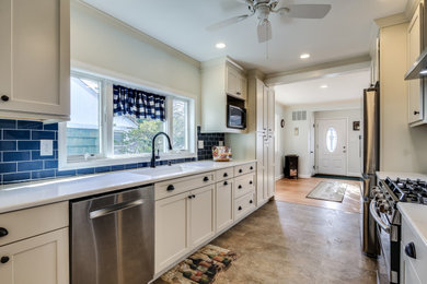Inspiration for a mid-sized craftsman galley laminate floor and multicolored floor kitchen pantry remodel in Baltimore with an undermount sink, shaker cabinets, beige cabinets, quartz countertops, blue backsplash, ceramic backsplash, stainless steel appliances, no island and white countertops