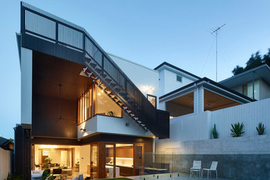 Mid-sized contemporary backyard full sun xeriscape in Brisbane with a retaining wall and concrete pavers for summer.