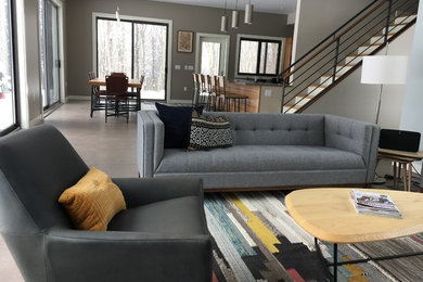 This is an example of a mid-sized modern formal open concept living room in Boston with grey walls, concrete floors, no fireplace, no tv and grey floor.