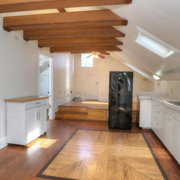 Attic Living Space with Exposed Box Beams and Custom Wood Parquet Floor