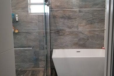 Inspiration for a large modern kids bathroom in Miami with flat-panel cabinets, white cabinets, a freestanding tub, a curbless shower, a one-piece toilet, white tile, porcelain tile, white walls, porcelain floors, a wall-mount sink, engineered quartz benchtops, multi-coloured floor and a sliding shower screen.