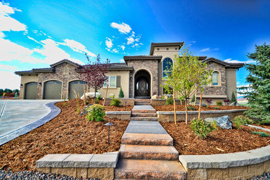 Photo of a mid-sized transitional two-storey beige exterior in Denver with stone veneer.