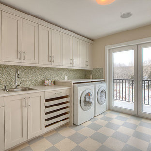Inspiration for a large traditional single-wall separated utility room in Calgary with a built-in sink, shaker cabinets, beige cabinets, laminate countertops, beige walls, lino flooring, a side by side washer and dryer and multi-coloured floors.