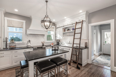 Large elegant l-shaped dark wood floor and brown floor eat-in kitchen photo in Philadelphia with recessed-panel cabinets, white cabinets, white backsplash, stainless steel appliances, an island, a drop-in sink and stone tile backsplash
