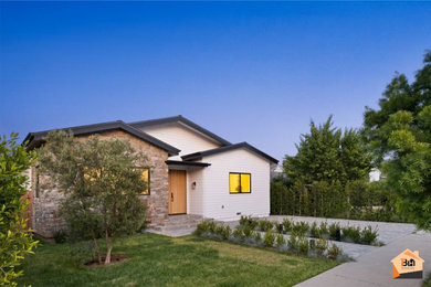 Cottage multicolored one-story stone house exterior photo in Los Angeles with a black roof