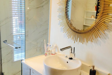 Inspiration for a modern gray tile and ceramic tile ceramic tile bathroom remodel in Montreal with white cabinets, a two-piece toilet, white walls, a vessel sink and quartzite countertops