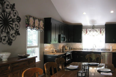 Mid-sized elegant l-shaped medium tone wood floor and brown floor eat-in kitchen photo in Richmond with an undermount sink, flat-panel cabinets, dark wood cabinets, granite countertops, white backsplash, subway tile backsplash, stainless steel appliances and no island