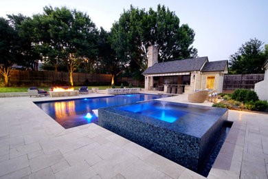 This is an example of a large modern backyard rectangular pool in Dallas with a hot tub.
