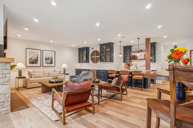 Basement - large transitional light wood floor basement idea in DC Metro with a bar and a standard fireplace
