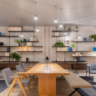 Idéer för stora funkis hemmabibliotek, med grå väggar, betonggolv, ett inbyggt skrivbord och grått golv