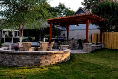 Patio kitchen - large traditional backyard concrete paver patio kitchen idea in Other with a pergola