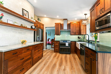 Example of a mid-sized tuscan u-shaped vinyl floor and brown floor eat-in kitchen design in Seattle with a farmhouse sink, shaker cabinets, brown cabinets, quartzite countertops, stainless steel appliances and multicolored countertops