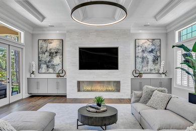 タンパにある高級な広いトランジショナルスタイルのおしゃれな独立型ファミリールーム (白い壁、無垢フローリング、標準型暖炉、石材の暖炉まわり、茶色い床、格子天井) の写真