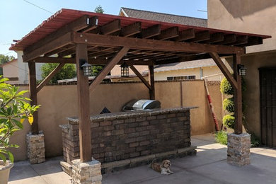 Example of a mid-sized classic backyard concrete patio kitchen design in Los Angeles with a pergola