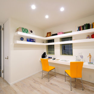 Design ideas for a modern home office and library in Other with white walls, painted wood flooring, a built-in desk and beige floors.