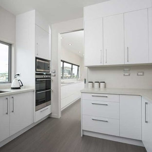 Large contemporary kitchen pantry inspiration - Inspiration for a large contemporary galley kitchen pantry remodel in Hamilton with an integrated sink, granite countertops, white backsplash, stainless steel appliances and an island