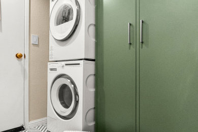 Small transitional single-wall ceramic tile and white floor utility room photo in San Francisco with shaker cabinets, green cabinets, beige walls and a stacked washer/dryer