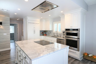 Inspiration for a mid-sized transitional l-shaped eat-in kitchen remodel in Los Angeles with beaded inset cabinets, white cabinets, quartz countertops, gray backsplash, quartz backsplash, stainless steel appliances, an island and gray countertops