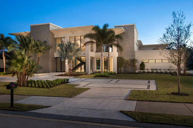 Photo of a large modern two-storey stucco brown house exterior in Orlando with a flat roof.
