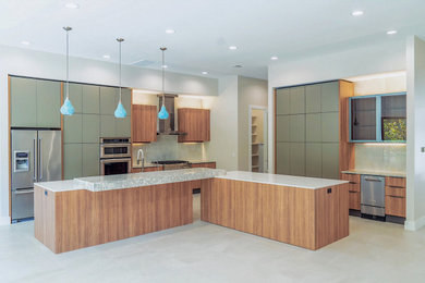 Example of a large trendy l-shaped eat-in kitchen design in Houston with flat-panel cabinets, stainless steel appliances and white countertops