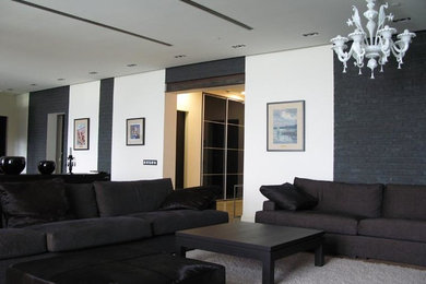 Imagen de sala de estar tipo loft ecléctica grande con paredes negras, suelo de madera en tonos medios y televisor colgado en la pared