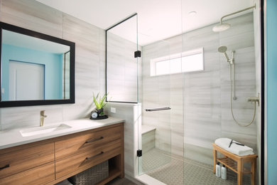 Example of a mid-sized trendy gray tile and porcelain tile vinyl floor, gray floor and single-sink bathroom design in Toronto with flat-panel cabinets, medium tone wood cabinets, a one-piece toilet, an undermount sink, quartz countertops, a hinged shower door, white countertops and a built-in vanity