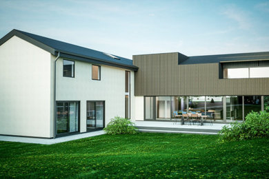 Diseño de fachada de casa gris y gris grande de dos plantas con revestimiento de madera, tejado plano y tejado de varios materiales