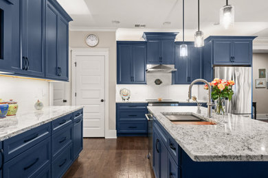 Kitchen - mid-sized transitional l-shaped medium tone wood floor and brown floor kitchen idea in Birmingham with an undermount sink, flat-panel cabinets, blue cabinets, granite countertops, stainless steel appliances and an island