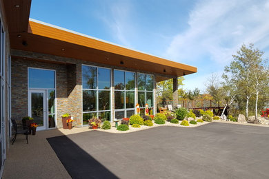 Example of a large trendy brown two-story stone exterior home design in Other