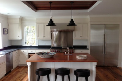 Inspiration for a mid-sized transitional l-shaped medium tone wood floor and brown floor eat-in kitchen remodel in Boston with a farmhouse sink, beaded inset cabinets, beige cabinets, quartz countertops, metallic backsplash, metal backsplash, stainless steel appliances and an island
