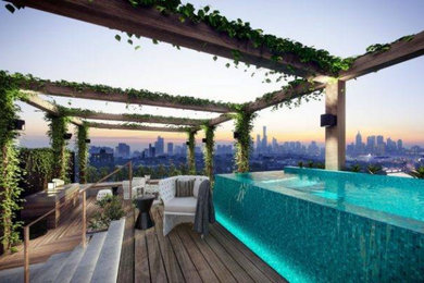 Example of a mid-sized minimalist rooftop tile and rectangular infinity pool house design in Other