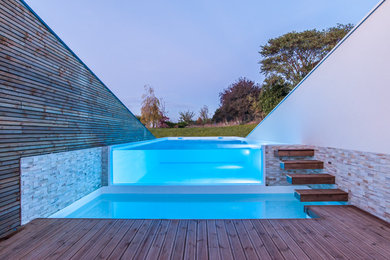 Idée de décoration pour une piscine à débordement minimaliste.