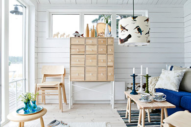 Inspiration for a small scandinavian open concept living room in Stockholm with white walls and light hardwood floors.