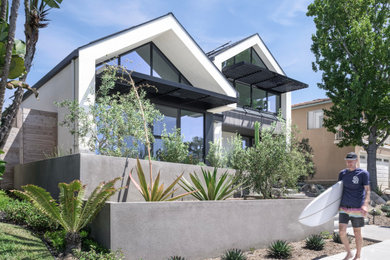 Идея дизайна: белый частный загородный дом в стиле модернизм с облицовкой из цементной штукатурки, двускатной крышей, крышей из гибкой черепицы и черной крышей