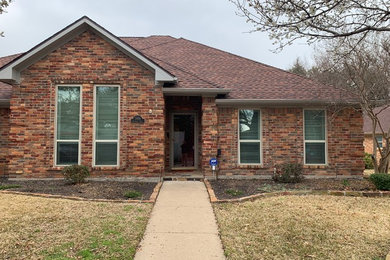 Mid-sized traditional brown one-story brick house exterior idea in Dallas with a hip roof and a shingle roof