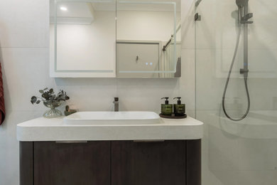 Large contemporary bathroom in Sydney with flat-panel cabinets, dark wood cabinets, a freestanding tub, an alcove shower, a bidet, beige tile, white walls, a drop-in sink, beige floor, a sliding shower screen, white benchtops, a niche, a single vanity and a freestanding vanity.
